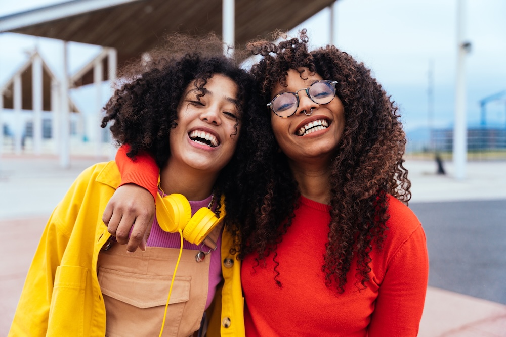 two teen girls smiling and hugging